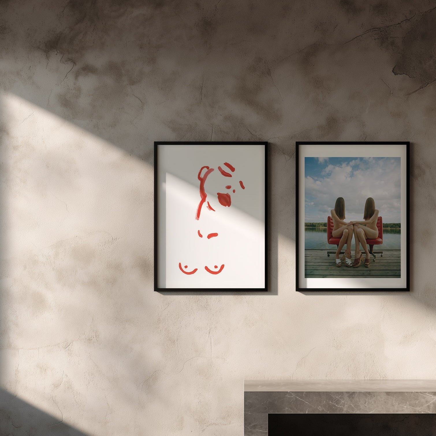 Two framed artworks on a textured wall with a soft light source.