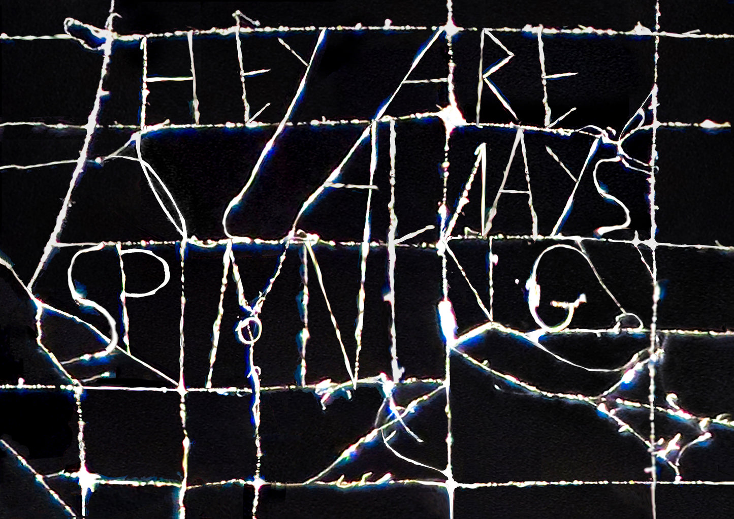 Text 'THEY ARE ALWAYS SPYING' on a cracked glass surface